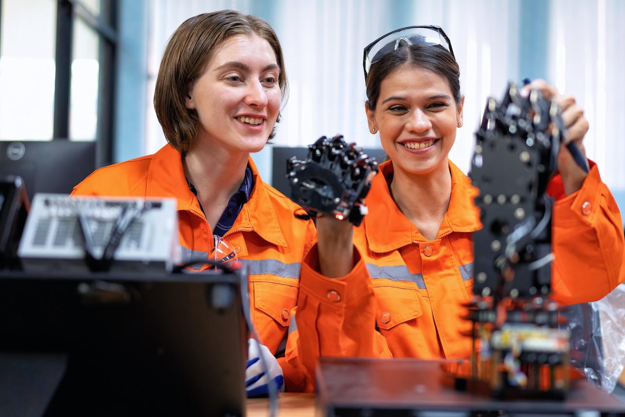 girl engineer in robot industry fabrication research room simulate testing robot arm on operation