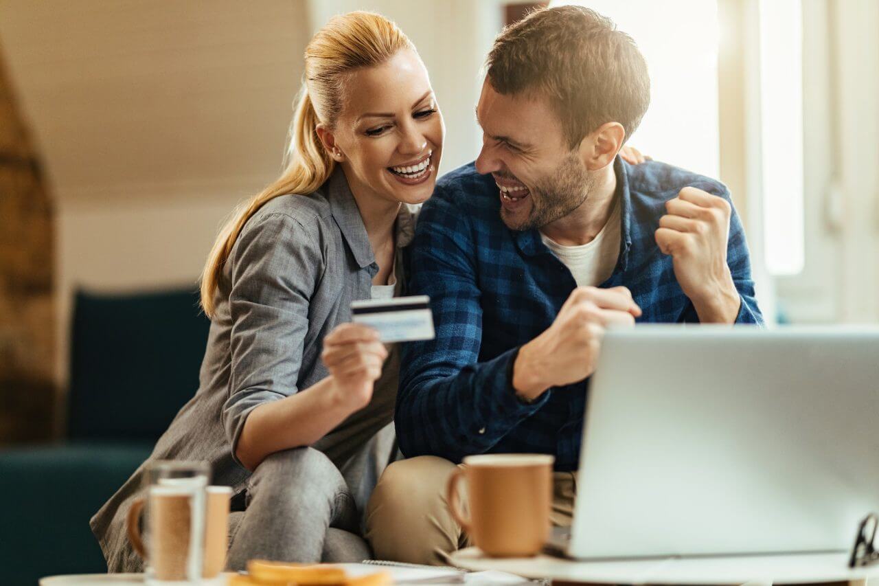 happy-couple-celebrating-while-using-credit-card-and-online-banking-at-home-.jpg