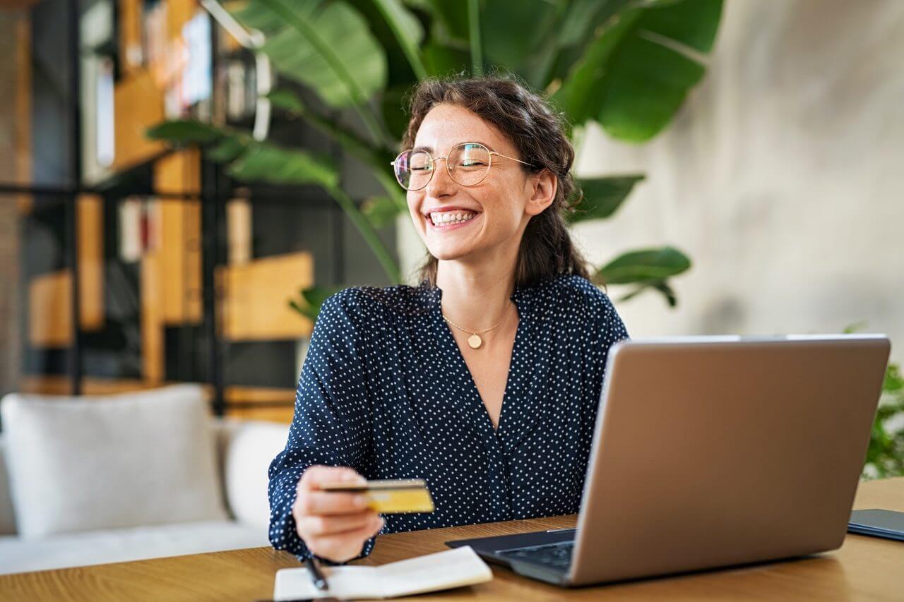 woman with laptop using credit card